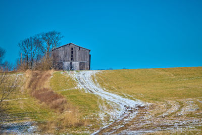 House by sea against clear blue sky