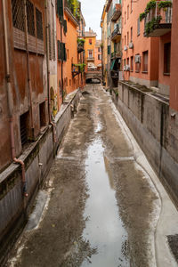 Canal amidst buildings in city during rainy season