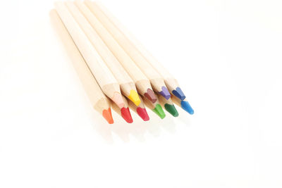 High angle view of colored pencils against white background