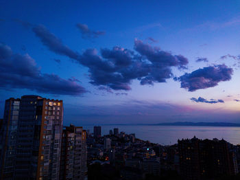 Silhouette buildings against blue sky at sunset