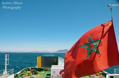 Red flags on mountain against clear blue sky