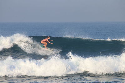 Man surfing in sea against clear sky