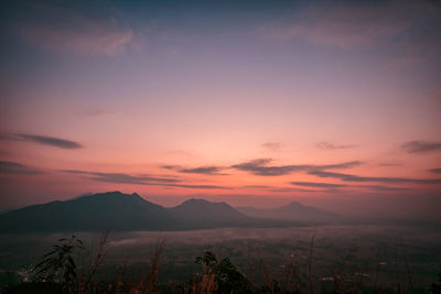 Scenic view of silhouette mountains against romantic sky at sunset