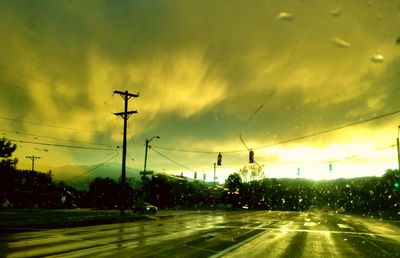 Cars on road against sky at sunset