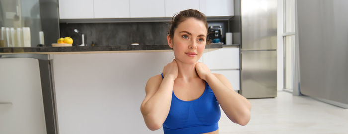 Portrait of young woman standing at home