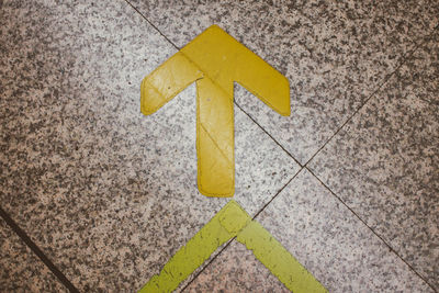 High angle view of arrow symbol on floor