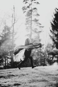 Full length of rear view of woman with scarf running on field