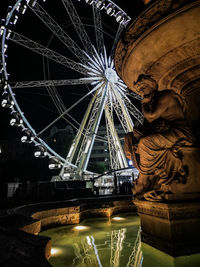 Low angle view of illuminated ferris wheel at night