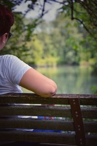 Rear view of woman on railing against trees