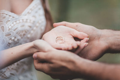 Midsection of young couple holding engagement rings