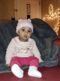 Portrait of cute baby girl sitting at home