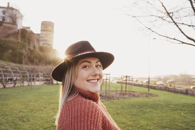 Portrait of smiling young woman standing against sky