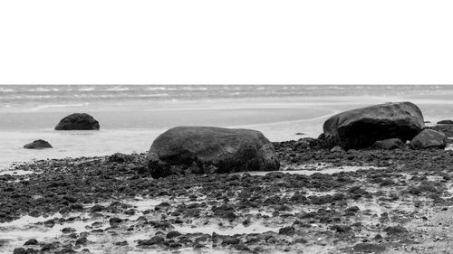 Scenic view of rocks on beach against sky