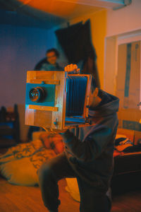 Young man photographing at home