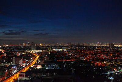 High angle view of illuminated cityscape against sky at night