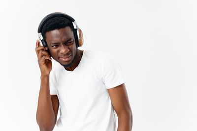 Portrait of young man standing against white background