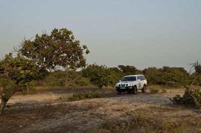 Car on field against clear sky