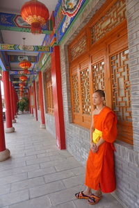 Woman standing on floor against wall