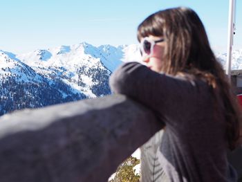 Side view of girl against snowcapped mountains