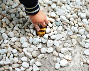 Cropped image of kid playing with toy car