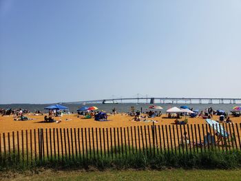 People on beach against clear sky