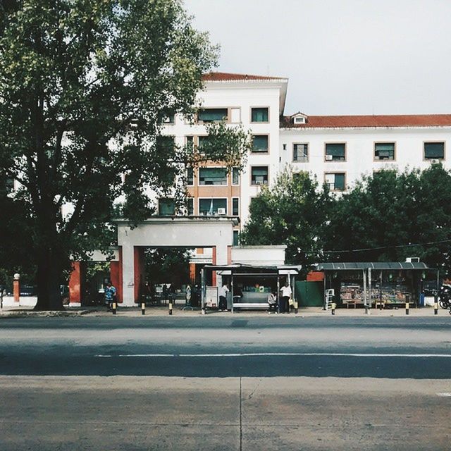 building exterior, architecture, built structure, street, tree, transportation, road, city, car, clear sky, land vehicle, road marking, mode of transport, incidental people, city life, building, outdoors, residential structure, day, residential building