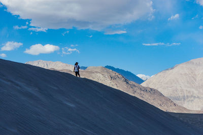 Young women on sand dune at high altitude in nubra valley against sky