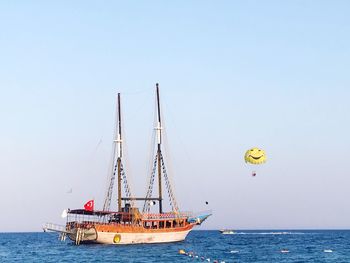 Sailboat sailing in sea against clear sky