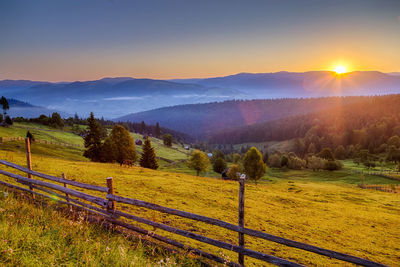 Scenic view of field against sky during sunset