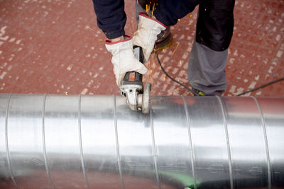 High angle view of industry worker cutting steel with angle grinder