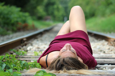 Woman lying on railroad tracks