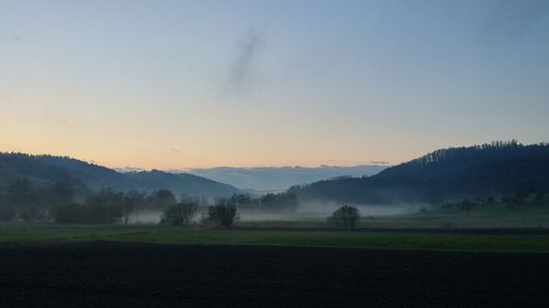 Scenic view of field against sky during sunset