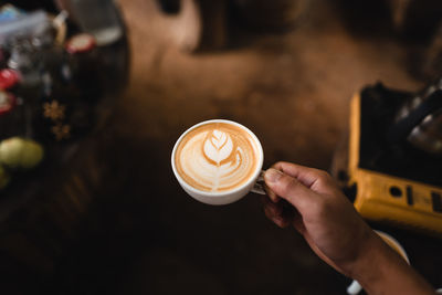 Cropped hand of woman holding coffee cup