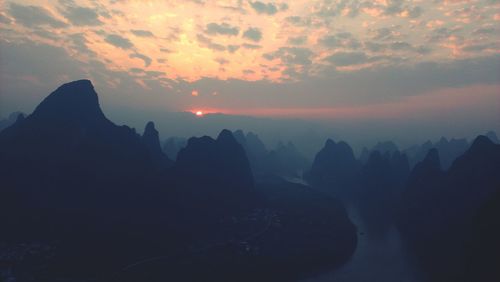 Scenic view of mountains against sky at sunset