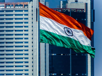 Low angle view of flag against building in city