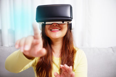 Young asian woman wearing virtual reality glasses, hand touching the air. vr headset. vr concept.