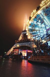 Illuminated ferris wheel against sky at night