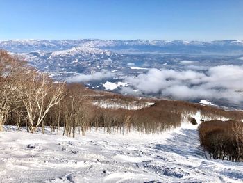 Scenic view of snowcapped mountains against blue sky