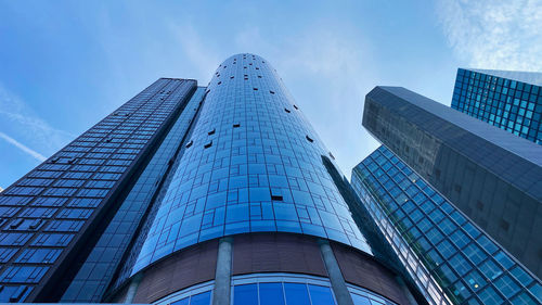 Low angle view of modern buildings against blue sky