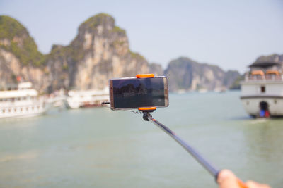 Man photographing sea against sky