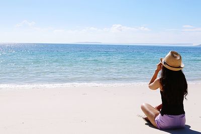 Rear view of woman looking at sea against sky