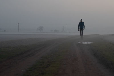 Rear view of man walking on road