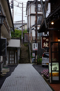 Empty footpath amidst buildings in city