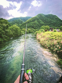 Scenic view of river amidst trees against mountains