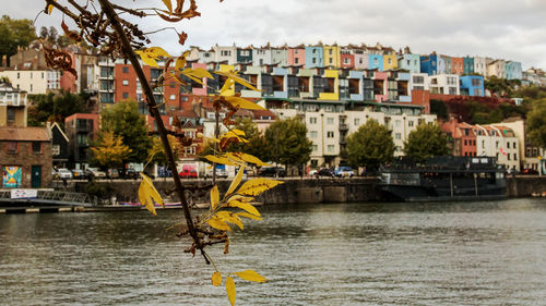 Scenic view of river by buildings against sky