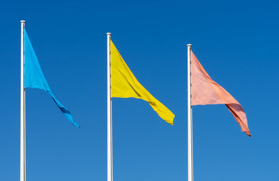 Low angle view of flag against blue sky