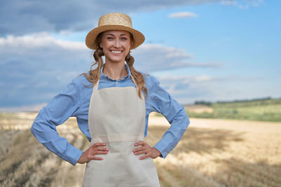 Portrait of a smiling young woman standing on field