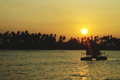 Silhouette boat in sea against sky during sunset