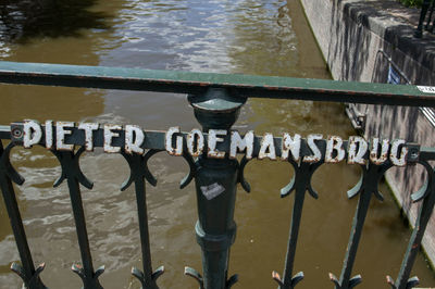 High angle view of text on railing by lake