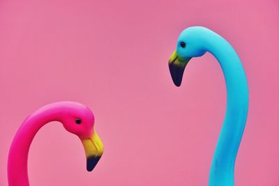 Close-up of artificial flamingoes against colored background